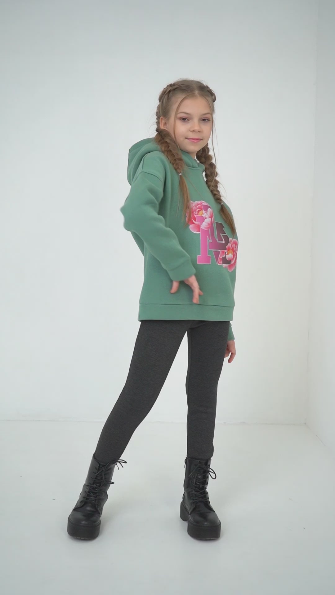 Mädchen mag die Kombination aus dem olivgrünen Pullover und den grauen Thermo-Leggings von Lemoni Boutique und zeigt sich gern in dem Outfit.