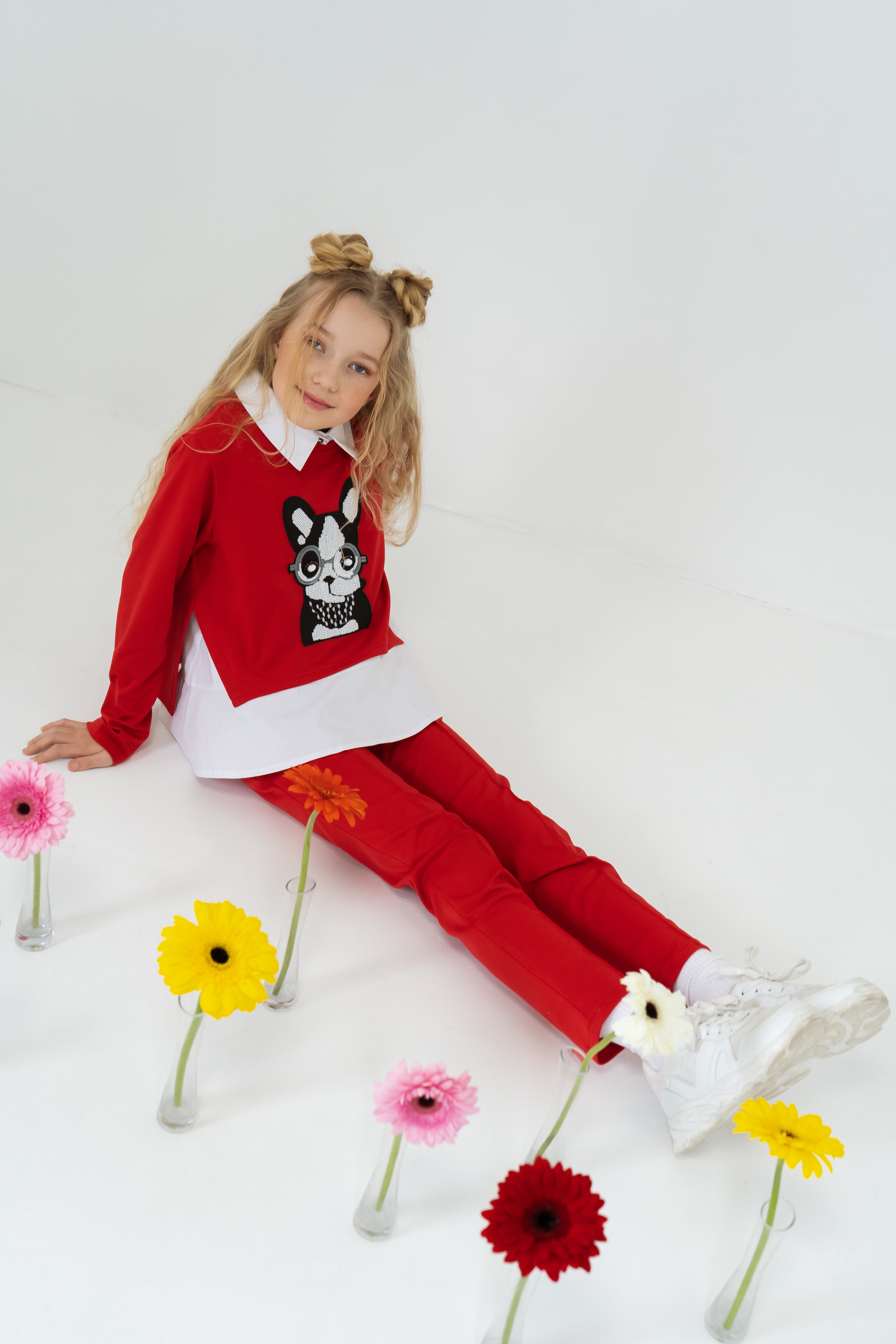 Girl´s red trousers, white blouse and red sweathirt dog