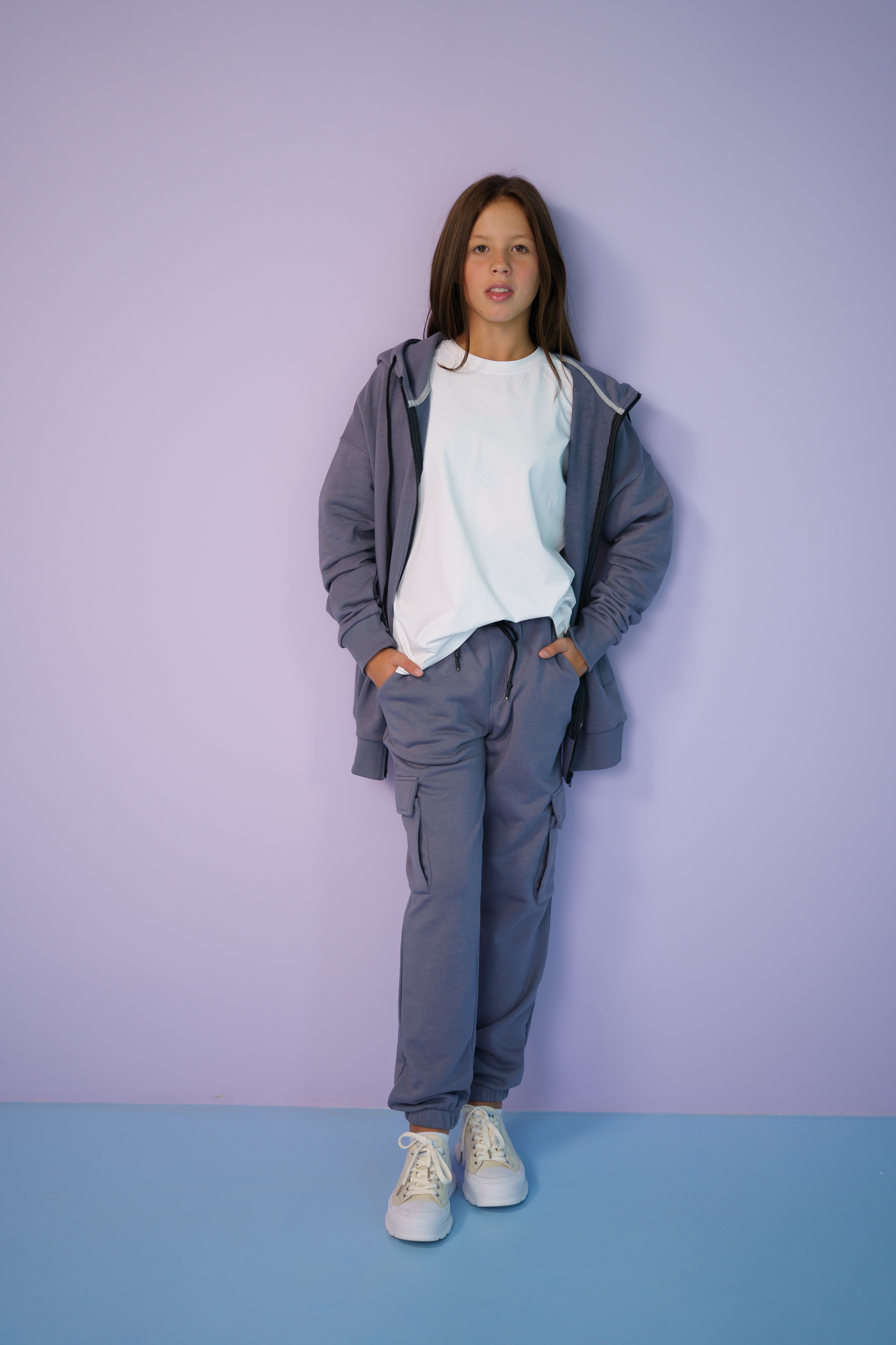 girl wearing a gray tracksuit and a white t-shirt