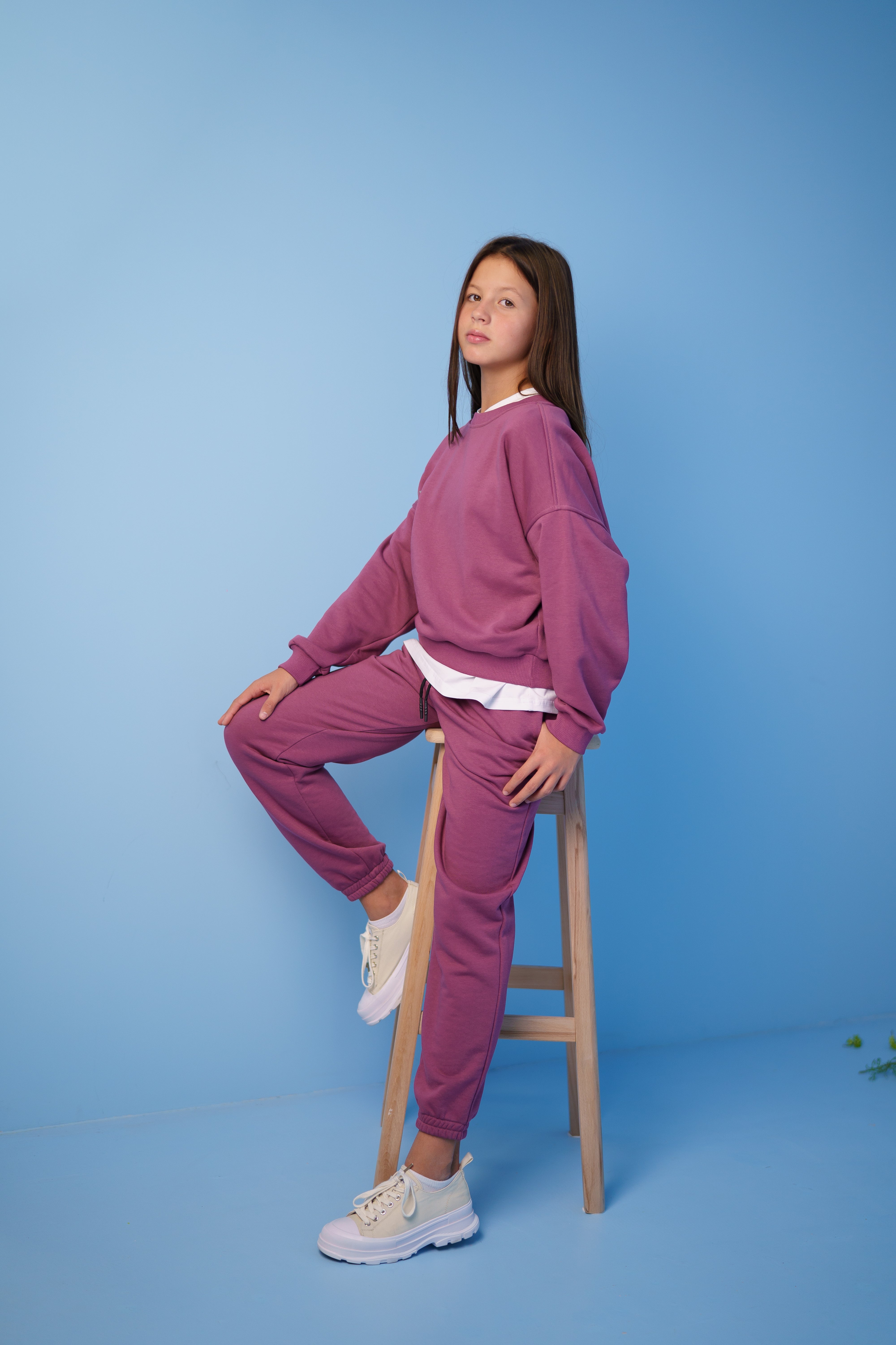 girl wearing a pink tracksuit by Lemoni sitting on the chair